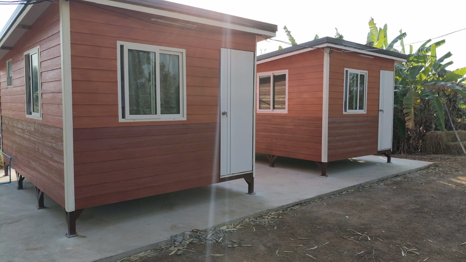 Two wooden bungalows in tropical Isaan setting